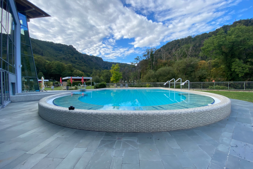 Rundes Außenbecken der Bodetal Therme Thale vor Bergpanorama