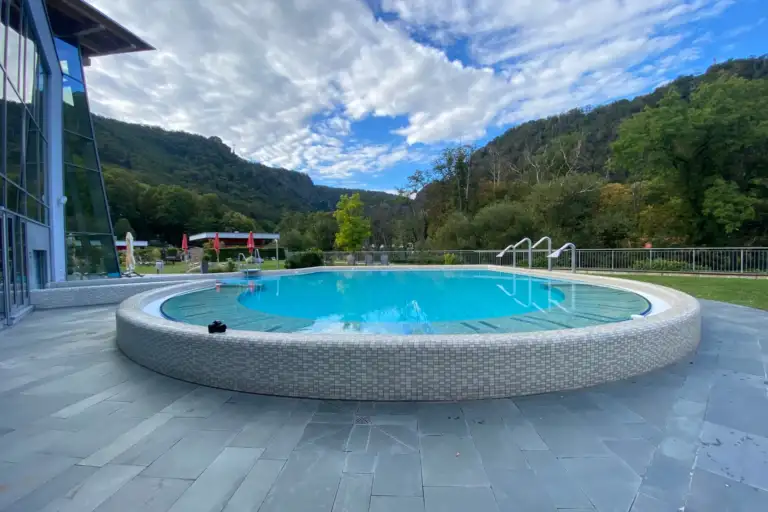 Rundes Außenbecken der Bodetal Therme Thale vor Bergpanorama