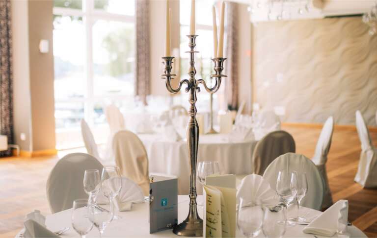 Festliche Tischdekoration mit Silberkandelaber und klassischer Restauranteinrichtung