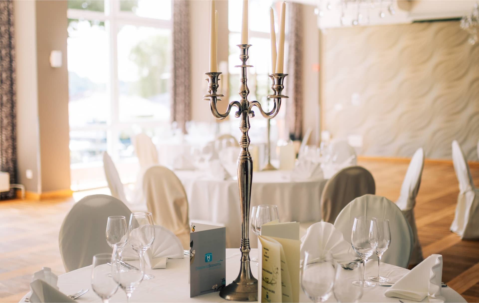 Festliche Tischdekoration mit Silberkandelaber und klassischer Restauranteinrichtung