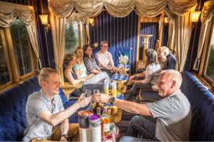 Reisegruppe sitzt gesellig im nostalgischen Salonwagen der Harzer Schmalspurbahnen bei einer Sonderfahrt
