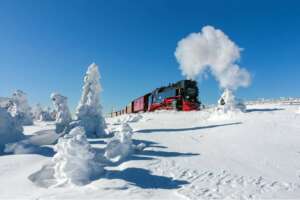 Dampflok der Harzer Schmalspurbahnen durchquert verschneite Hochharz-Landschaft mit Reif und Schnee