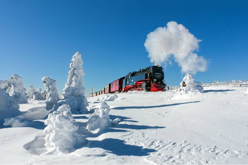 Dampflok der Harzer Schmalspurbahnen durchquert verschneite Hochharz-Landschaft mit Reif und Schnee