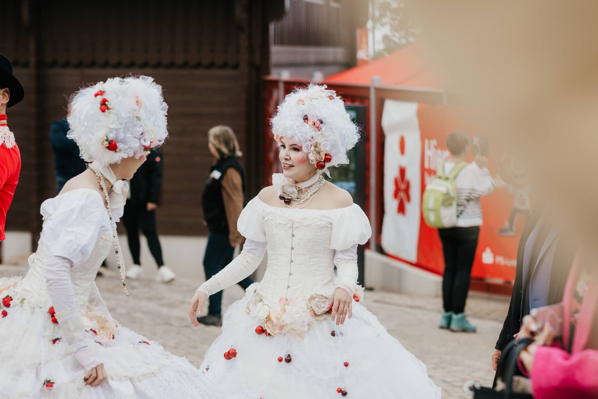 Zwei Künstlerinnen in barocker Tracht unterhalten sich vor dem Theater während einer Veranstaltung.