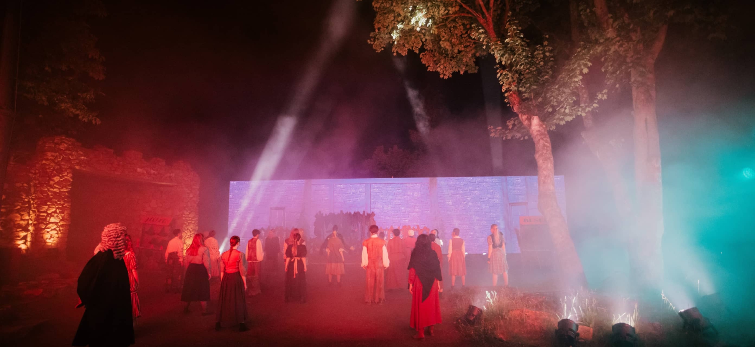 Abendliche Theaterszene mit Nebel und Lichtshow im Harzer Bergtheater, Darsteller in historischen Kostümen.