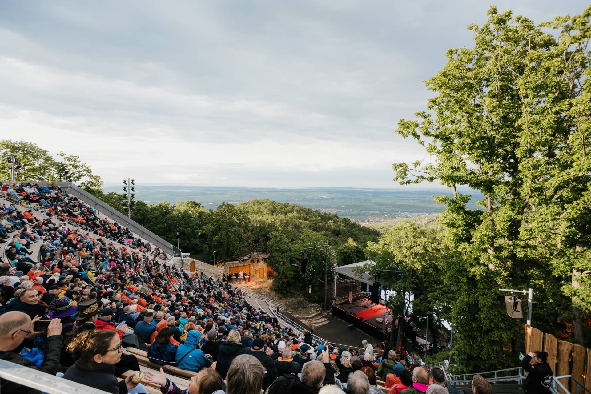 Großes Publikum im Harzer Bergtheater verfolgt eine Vorstellung mit Panoramablick ins Tal.