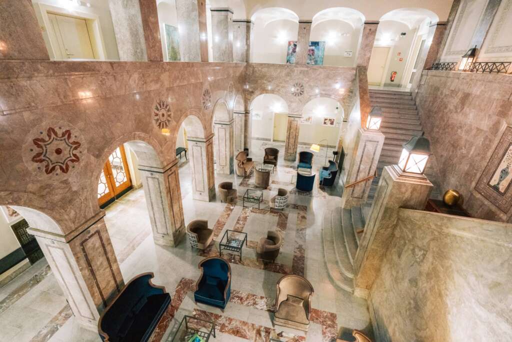 Hotellobby von oben mit Marmorarchitektur, Bögen und Sitzgruppen