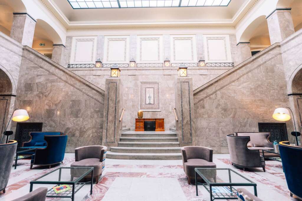 Repräsentativer Hotelsaal mit Doppeltreppe und Oberlicht