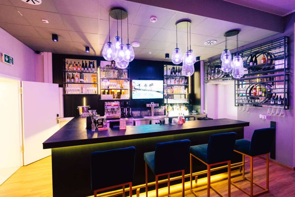 Hotelbar mit Theke, Barhockern und goldenem LED-Unterlicht