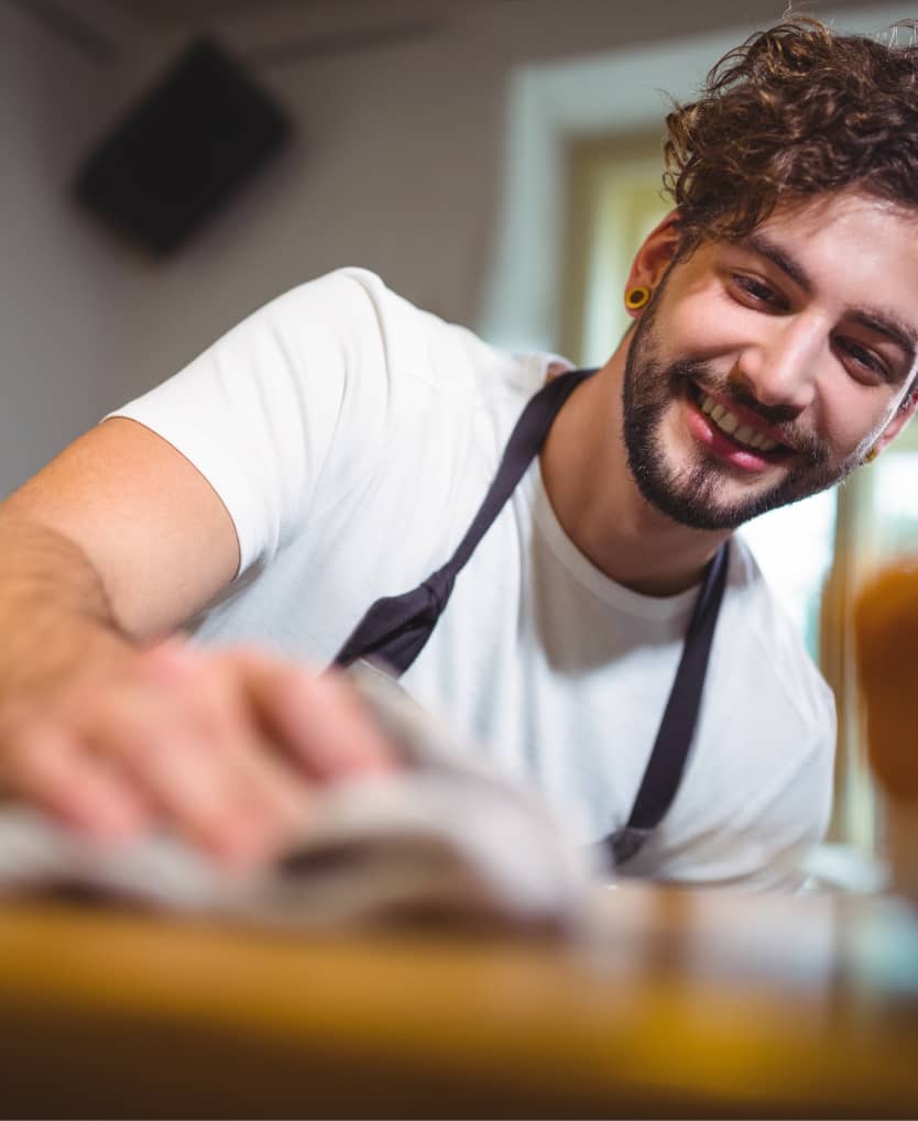 Freundlicher Service-Mitarbeiter beim Saubermachen in einem Apartment