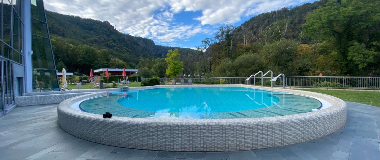 Rundes Außenbecken der Bodetal Therme Thale vor Bergpanorama